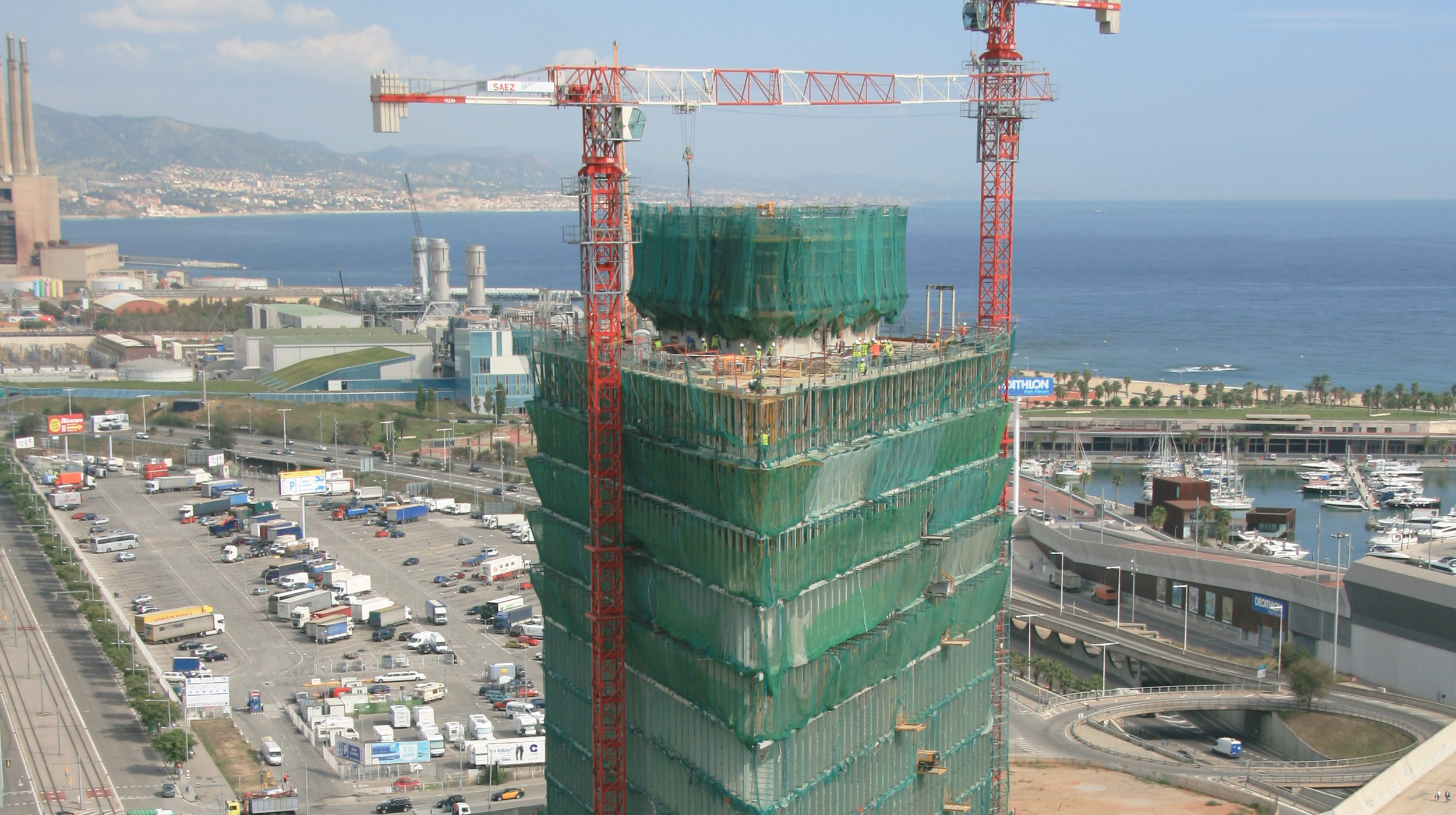 Ubicada junto al mar, en la Avenida Diagonal, alberga, entre otros, la sede de Telefónica en Cataluña. Sus 110 metros de altura y  24 plantas, le convierten en referente del skyline de Barcelona.